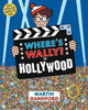 Front cover of the book 'Where's Wally? in Hollywood' by Martin Handford, featuring a cartoon character holding a large clapperboard over a crowded scene, with a blue background and a yellow 'With a special extra search in the back!' badge.