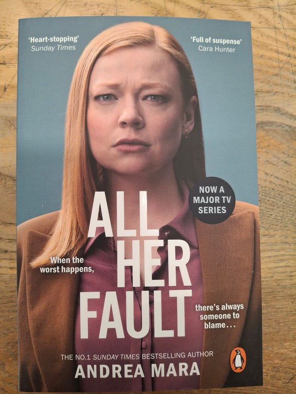 Book cover of 'All Her Fault' by Andrea Mara on a wooden surface