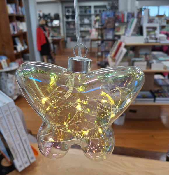 Clear butterfly-shaped ornament with string lights in a store setting