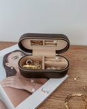 Open jewelry box with jewelry on a wooden surface and magazine underneath