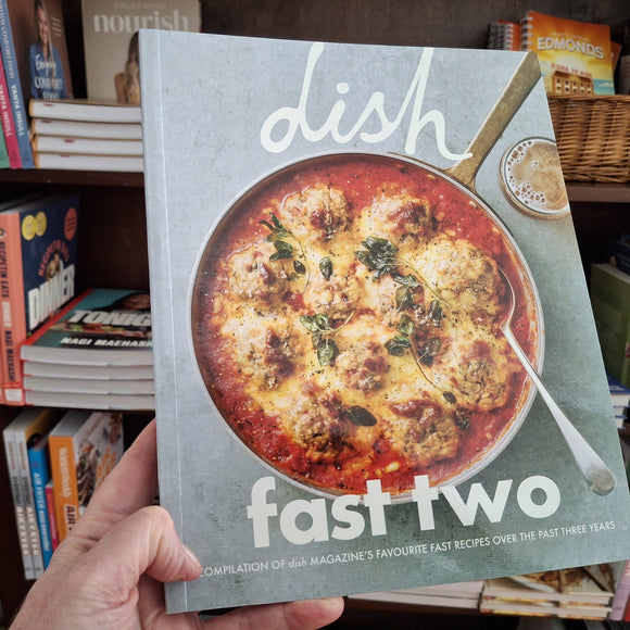 Book titled 'dish fast two' held by a hand with a blurred bookshelf background