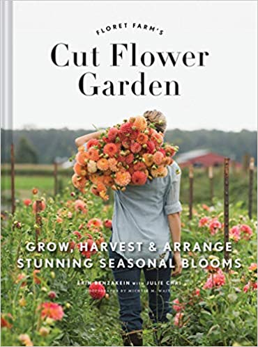 A cover image of the book titled 'Cut Flower Garden' showing a person with a basket of flowers standing in a field of blossoms.